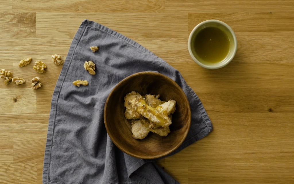 Walnut-crusted chicken breasts served in a bowl on a cloth napkin