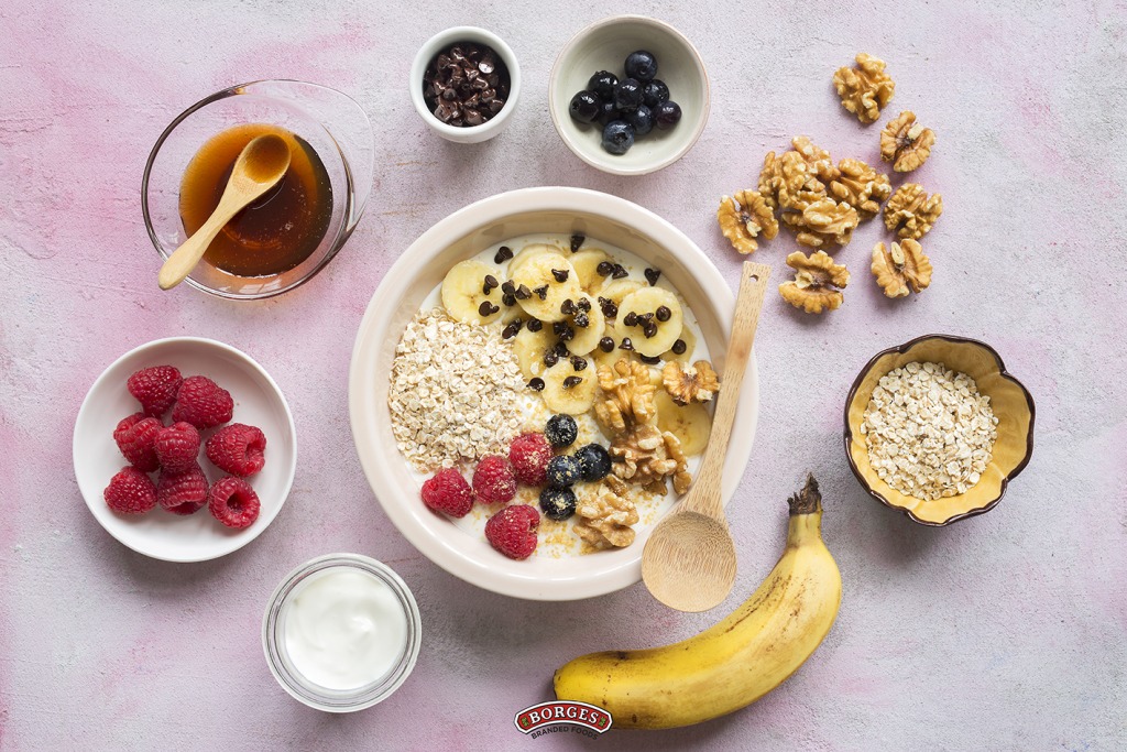 Healthy afternoon snack made of red fruits, banana, walnuts... just a multicolored bowl