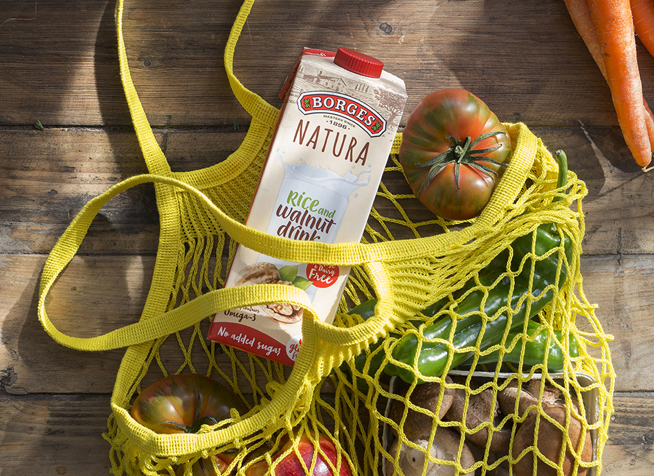 Supermarket bag with Borges Nature vegetable drink and a tomato. Eating healthy and some other tricks are the best tips to get back in shape after Christmas holidays