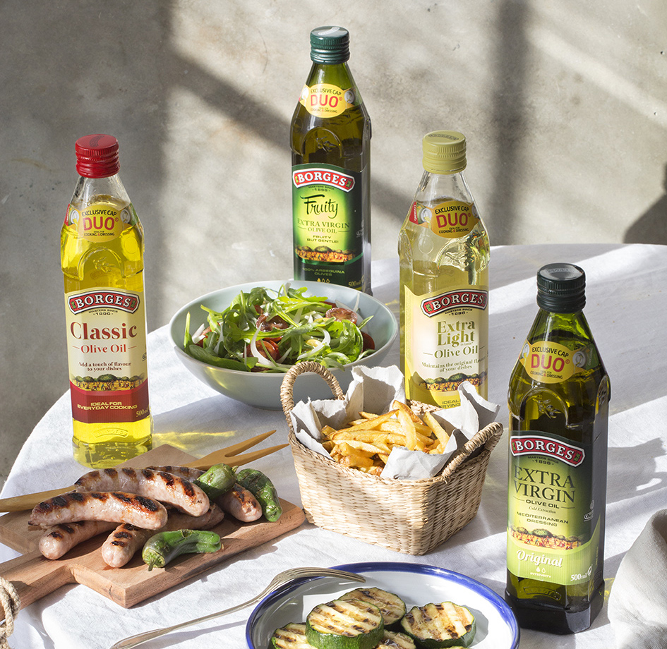 Different kinds of perfect olive oil on a table next to some dishes