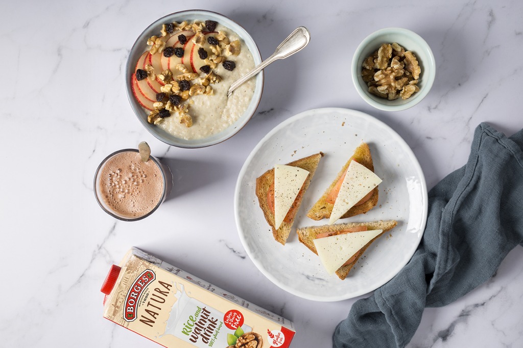 3 healthy breakfasts on the table such as toast with cheese, a porridge with cereals and nuts and a Borges Natura vegetable drink