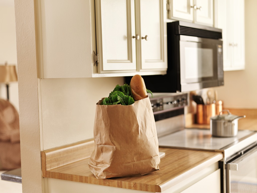 Get your pantry ready with foods like the ones seen in this photo: vegetables and bread on the kitchen counter