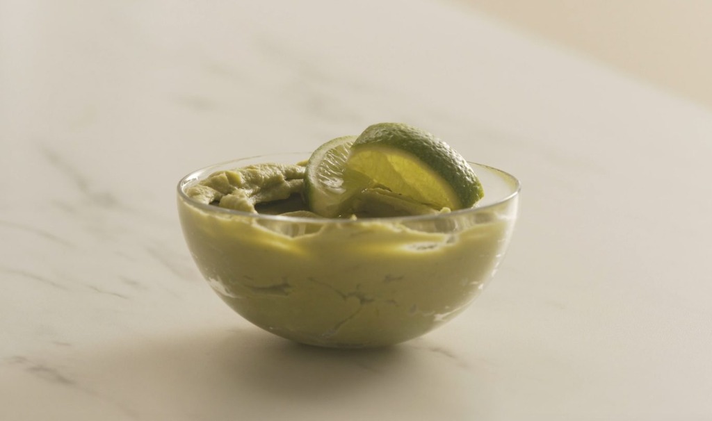 Hummus de aguacate servido en bol de cristal