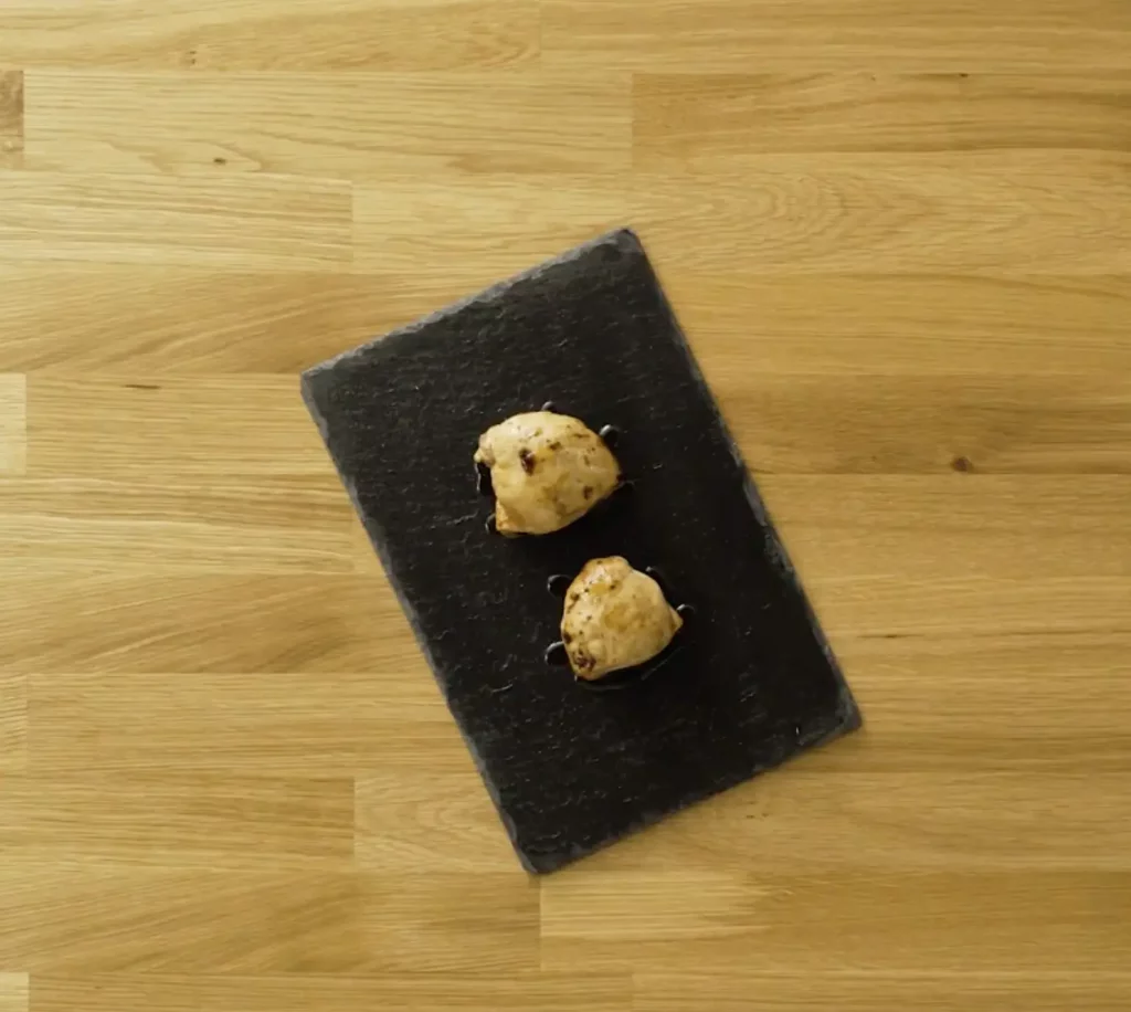 Roasted chicken breasts recipe served on a slate plate
