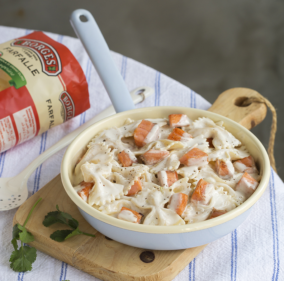 Smoked Salmon pasta served in a pan on a wooden cutting table