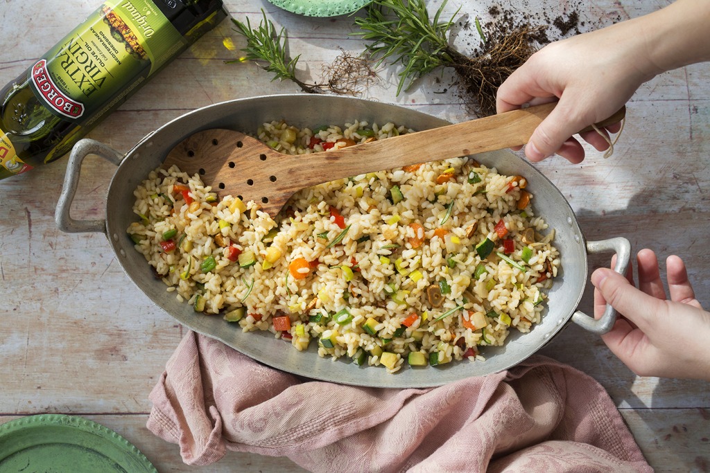Arroz frito con verduras servido en una fuentecon aceite de oliva Borges