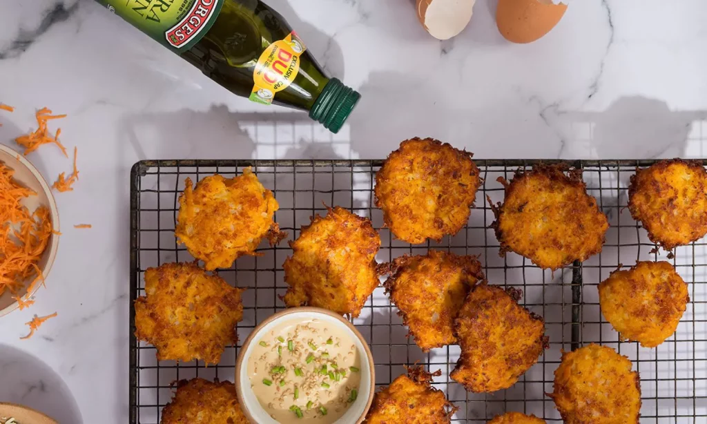 Buñuelos de boniato con salsa y aceite de oliva servidos sobre una rejilla