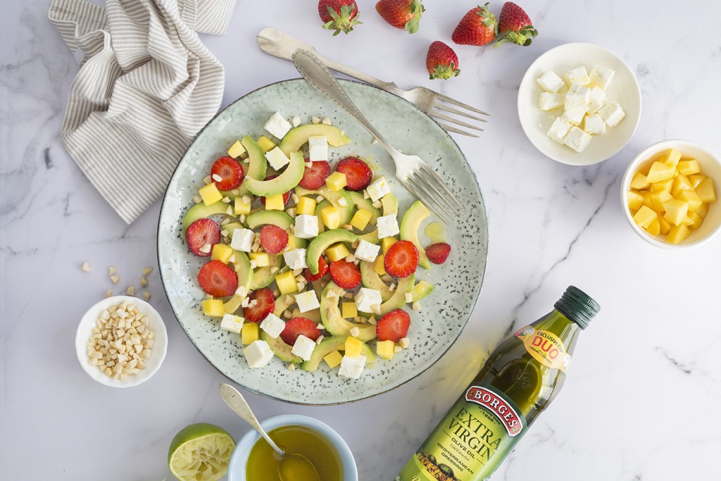 Plato de ensalada con aguacate, mango, fresas y queso