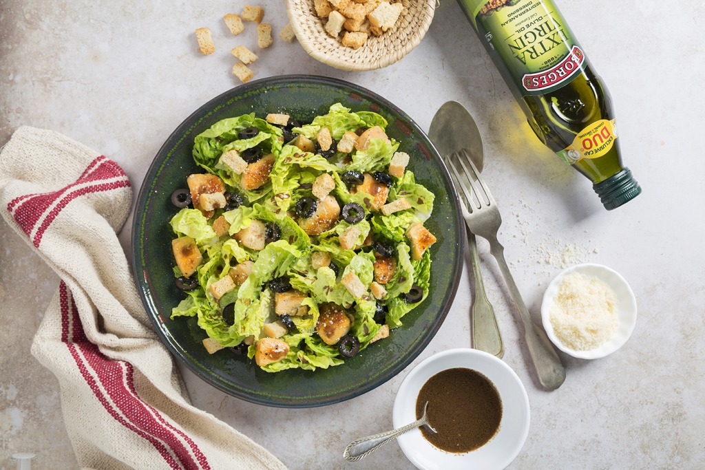 A healthy caesar salad with croutons, black olives and Borges olive oil