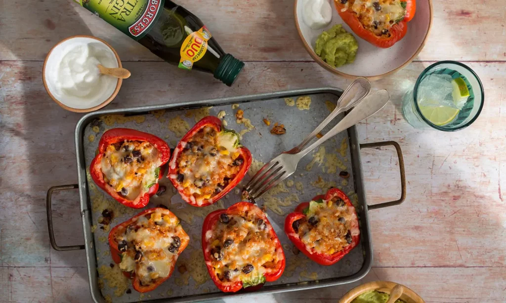 Stuffed ppepers recipe served in the oven tray with sauces and Borges olive oil