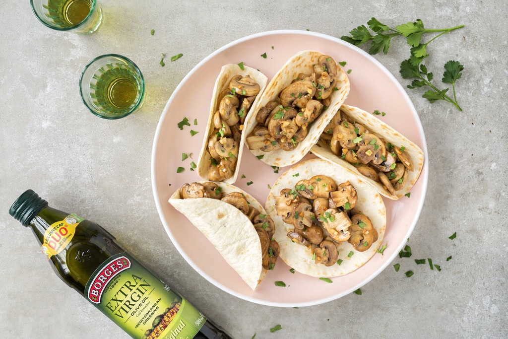 Plato con tacos de setas y botella de aceite de oliva virgen extra