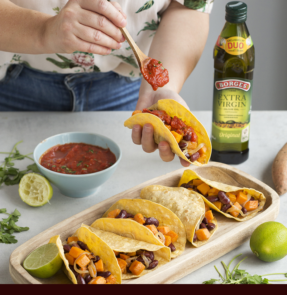 Tacos veganos de verduras servidos en una bandeja con salsa y aceite de oliva virgen extra Borges
